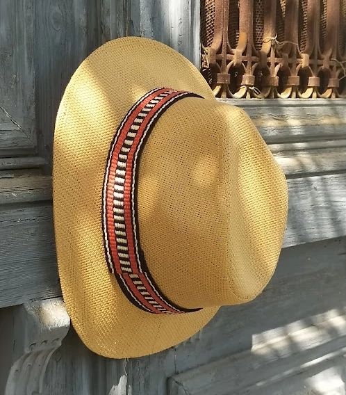 Hat with woven strap on old door